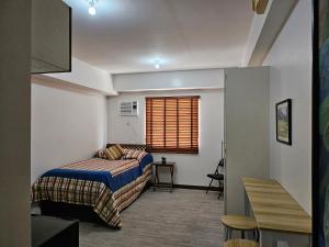 a bedroom with a bed and a window at Blue Jay 618 in Bacolod