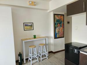 a kitchen with a counter and stools in a room at Blue Jay 618 in Bacolod