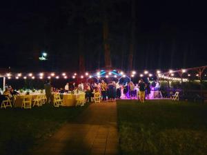 a group of people sitting at tables at night at Fern River Resort in Felton