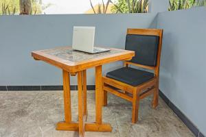 a wooden desk with a chair and a laptop on it at Hotel O Juanda Homestay Syariah in Pasuruan +23 photos