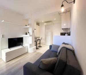 uma sala de estar com um sofá e uma televisão de ecrã plano em Le caroubier em Beausoleil
