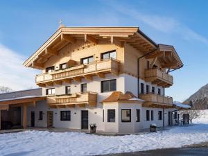 een gebouw met een balkon in de sneeuw bij Appartements Kafmahof in Söll