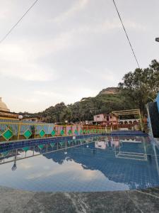 a large swimming pool with a reflection in the water at Blue Bell Homestay in Lonavala