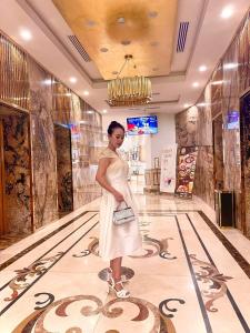 a woman in a white dress standing in a bowling alley at Luxury Ocean View Danang Golden Bay in Danang