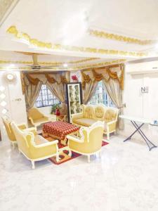 uma sala de estar com cadeiras amarelas e um sofá em Kakmas Homestay em Papar