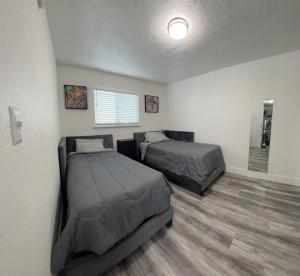 Habitación con 2 camas y ventana en Cozy and Spacious Home, en Las Vegas