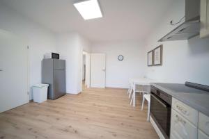 a white kitchen with a table and a refrigerator at DWK: Monteurwohnung Koblenz in Koblenz +5 photos