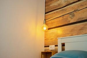 a light bulb hanging from a wall next to a bed at Apartment Iskra in Njivice