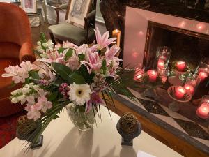 a vase of flowers on a table with candles at Au 16 Place Saint Louis in Blois