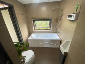 y baño con bañera, aseo y lavamanos. en THE LAND OF LOVE Homestay - Venuestay, en Dak Lak