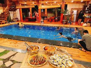 a buffet of food in front of a swimming pool at THE LAND OF LOVE Homestay - Venuestay in Dak Lak