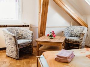 2 chaises et une table dans une pièce dans l'établissement REBENTISCH - HOTEL Ferienwohnungen Restaurant, à Hasselfelde