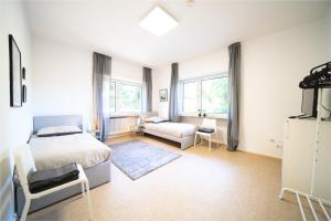 a bedroom with a bed and a couch and windows at DWK: Monteurwohnung Koblenz in Koblenz