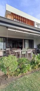 a house with a patio with chairs on it at Ravissante maison sur les hauteurs in Faaa