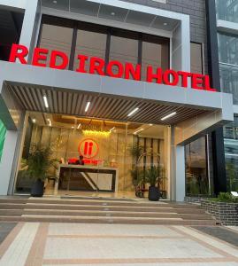Red Iron Hotel في كالبايوغ: مبنى فندق حديد احمر مع علامة فندق حديد حمراء