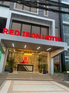 un cartello di ferro rosso sull'ingresso di un edificio di Red Iron Hotel a Calbayog