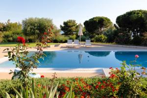 a swimming pool with two chairs and a umbrella at Pefkides in Marathopoli