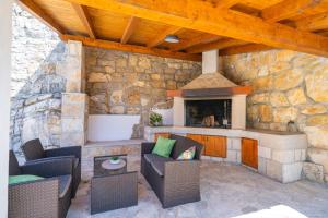 una sala de estar al aire libre con una pared de piedra. en Villa Stone House Kuna, en Pridvorje