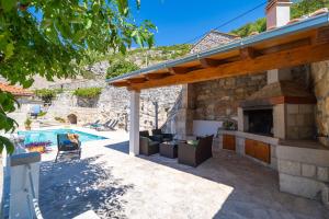 un patio con chimenea junto a una piscina en Villa Stone House Kuna, en Pridvorje