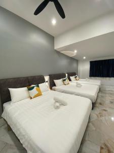a row of three beds in a room at IPOH LYL EVERGREEN HOMESTAY 12pax in Ipoh