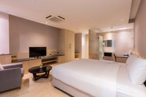 - une chambre avec un grand lit blanc et un canapé dans l'établissement Sukhothai Residence Ruam Ruedi, à Bangkok