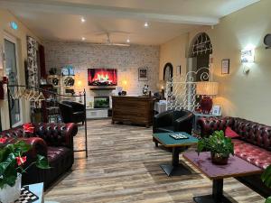 sala de estar con muebles de cuero y chimenea en Le Crist'Al Hôtel de charme en bord de mer, en Saint-Georges-de-Didonne