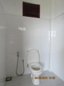 een witte badkamer met een toilet en een douche bij Green View Holiday Resort in Elkaduwa