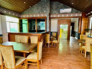 a dining room with a wooden table and chairs at Hotel Suryadev in Pālampur