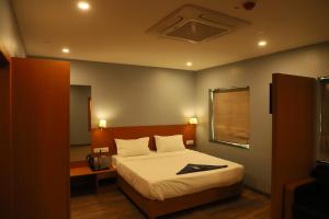 sypialnia z łóżkiem, lustrem i oknem w obiekcie Flora hotel w mieście Dźodhpur