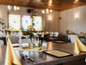 a table with a vase of flowers on top of it at REBENTISCH - Hotel FERIENWOHNUNGEN Restaurant in Hasselfelde