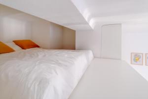 a bedroom with a white bed and orange accents at Castle Proximity Suite by Rentez in Prague