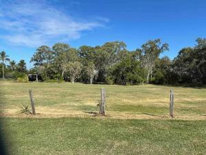 a fence in a field with trees in the background at Cosy house among the trees in Pemberton