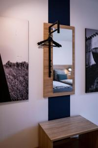 a mirror on a wall next to two pictures at Stadtplatz23 B&B in Bogen