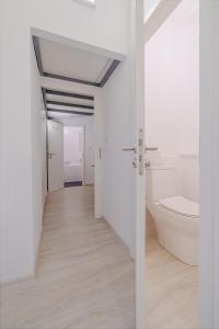 a white bathroom with a toilet and a sink at Castle Proximity Suite by Rentez in Prague