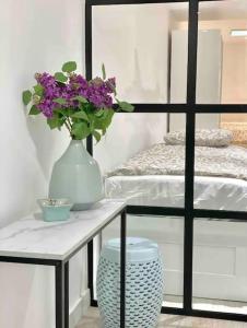 un tavolo con un vaso con fiori viola di Moderno apartamento con garaje privado en el centro de Vigo a Vigo Altre 13 foto