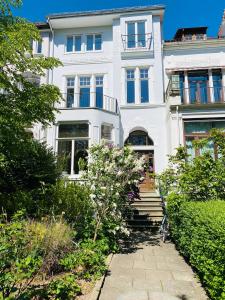 a large white house with a pathway in front of it at Jugendstil-Traumwohnung direkt am Weserstadion in Bremen