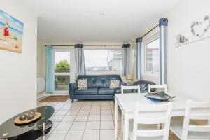 een woonkamer met een bank en een tafel bij Seaside Retreat Norfolk in Bacton