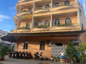 een groep motorfietsen geparkeerd voor een gebouw bij Huỳnh Hương Guesthouse in Ha Tien