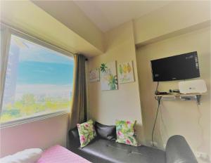 a bedroom with a large window and a tv at Avida Atria Tower 1 Studio Type Condominium in Iloilo City