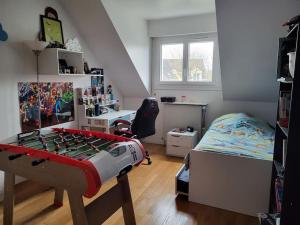 een kleine slaapkamer met een bed en een bureau bij Maison indépendante avec jardin, ville JO 2024 in Vaires-sur-Marne