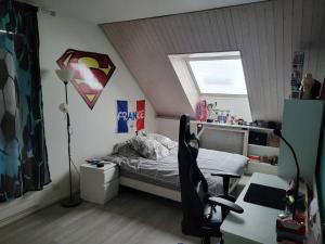 een slaapkamer met een bed, een bureau en een stoel bij Maison indépendante avec jardin, ville JO 2024 in Vaires-sur-Marne
