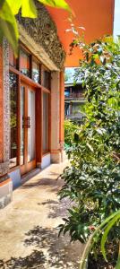 an orange building with a tree in front of it at Villa Biyu Siyu in Ubud