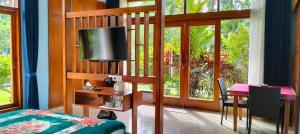a bedroom with a bed and a television and a table at Villa Biyu Siyu in Ubud