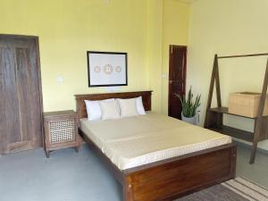 ein Schlafzimmer mit einem Bett mit Holzrahmen in der Unterkunft Society Ahangama in Ahangama