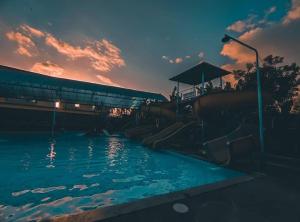una piscina con scivolo in acqua al tramonto di Srinadi Waterpark Villa a Klungkung
