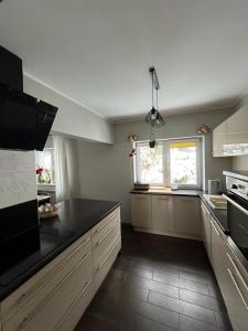 a kitchen with white cabinets and a black counter top at Domek w dolinie in Berest