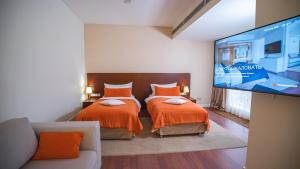 a bedroom with two beds and a flat screen tv at Park Hotel Almaty in Almaty