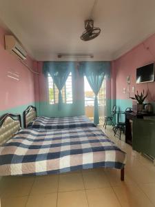 a bedroom with a bed with blue and pink walls at Huỳnh Hương Guesthouse in Hà Tiên