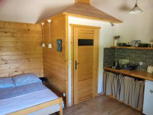 a bedroom with a bed and a wooden wall at Agroturystyka Klimaty- apartamenty nad rzeką in Międzylesie