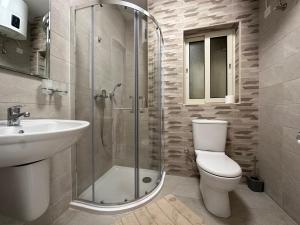 a bathroom with a toilet and a sink and a shower at DoMiSol duplex suites near sea in St. Paul's Bay +101 photos